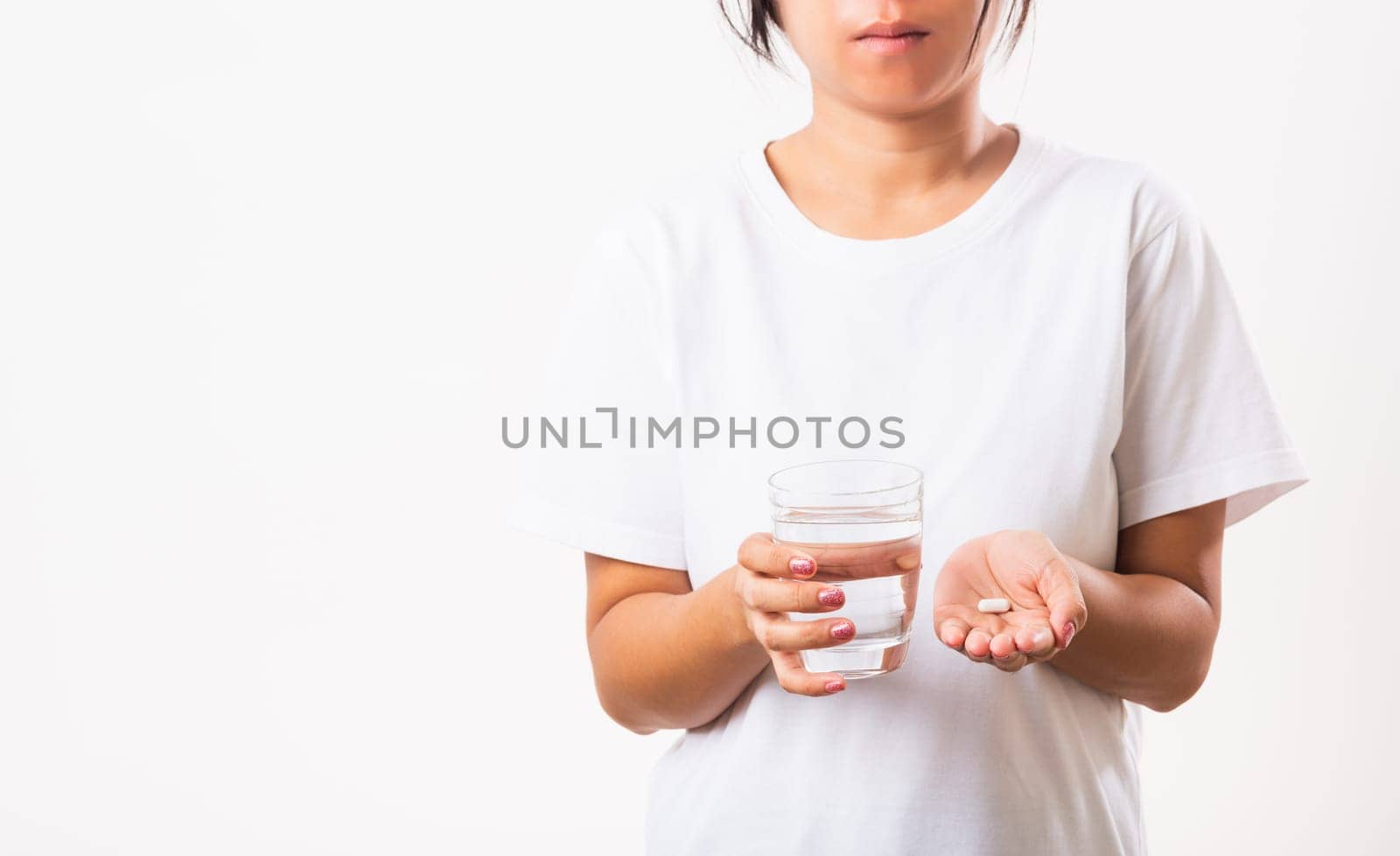 Closeup young Asian woman hold pill drugs in hand ready take medicines with a glass of water, studio shot isolated on white background, Healthcare and medical pharmacy concept