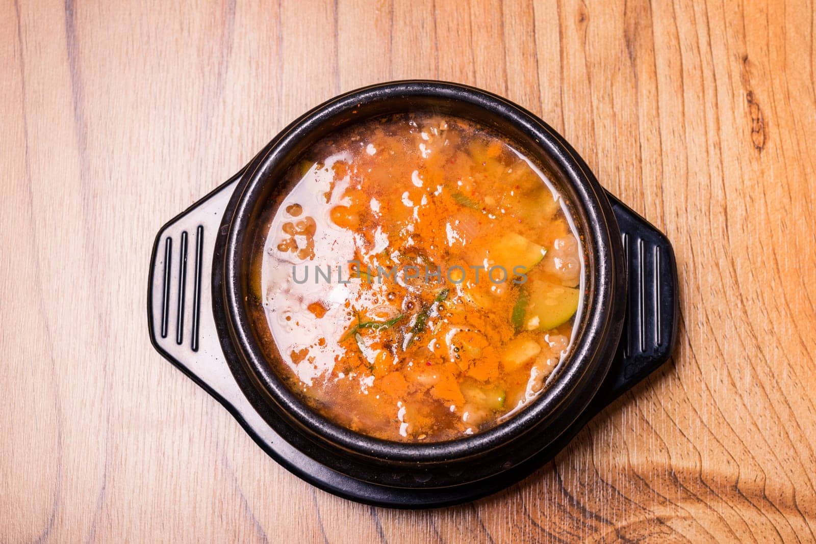 Kimchi soup in hot black iron pot, Korean traditional Kimchi Jjigae soup in bowl in the restaurant, Japanese hot pot food