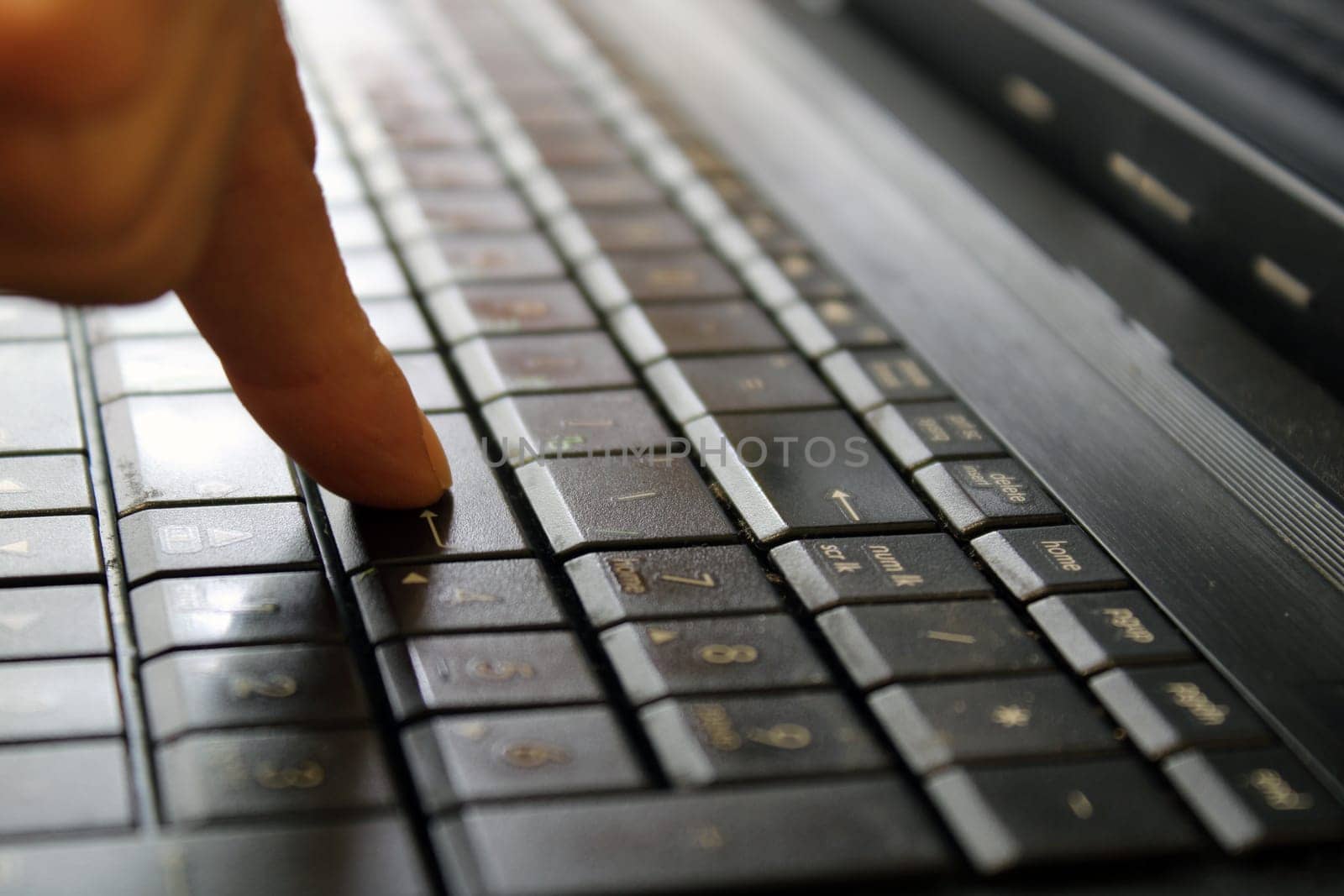 Finger of a female hand press a key on the keyboard of the laptop. Payment Security Concept..