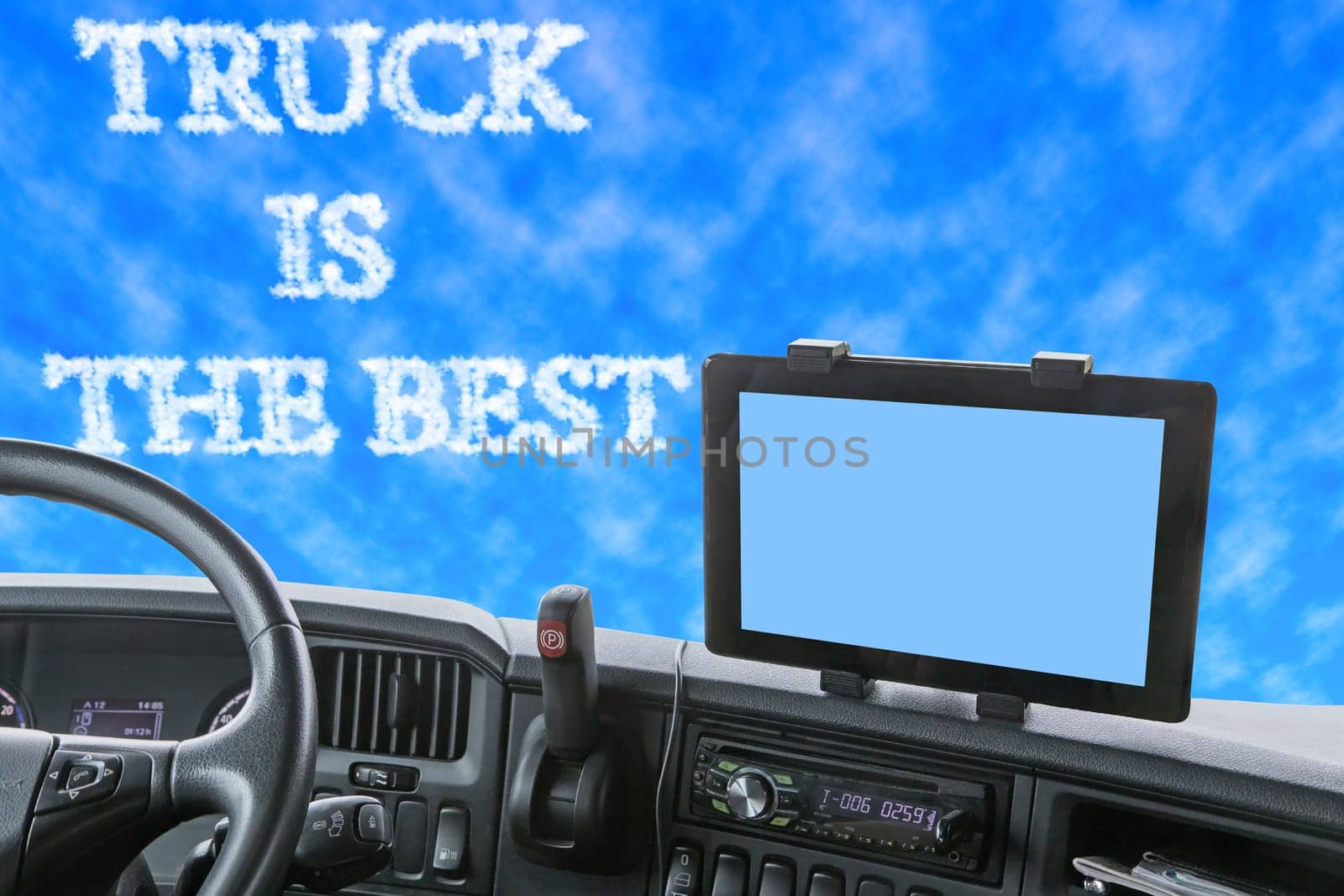 Dashboard of the truck with blue sky in front of the car. The inscription TRUCK IS THE BEST is formed from clouds in the blue sky. Navigation display is colored in light blue and is ready for your text.