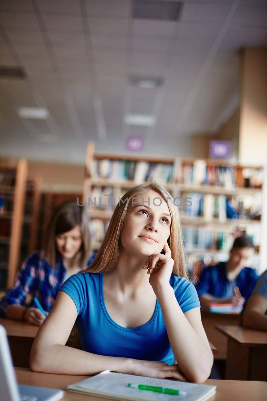 Cute girl daydreaming at lesson in college
