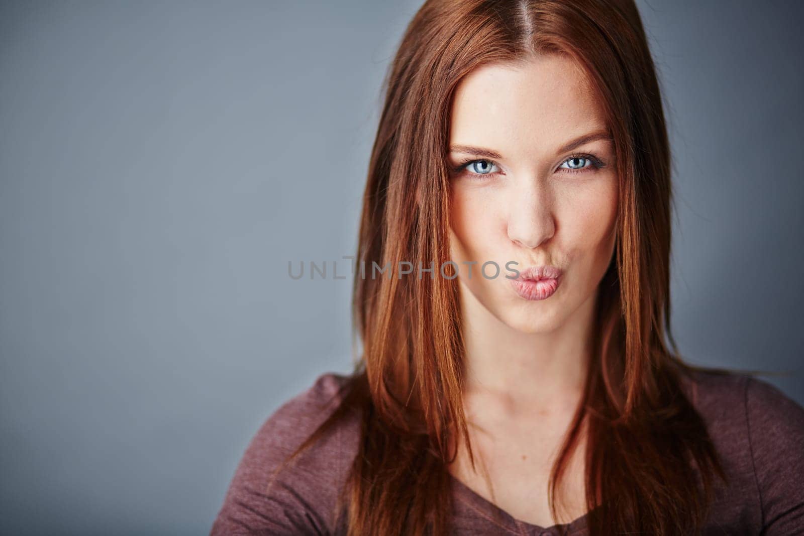 Young woman expressing air kiss while looking at camera