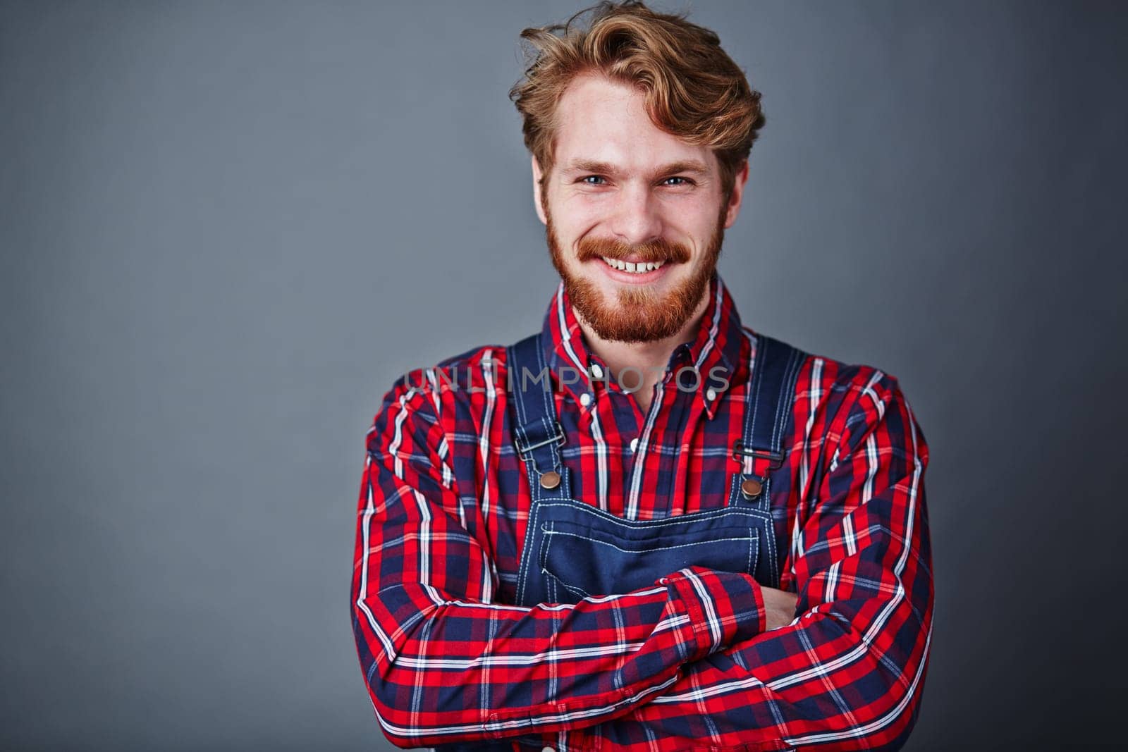 Handsome guy in coveralls looking at camera with smile