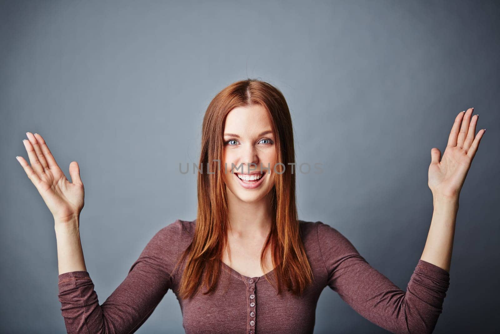 Happy young woman keeping her arms raised up and open