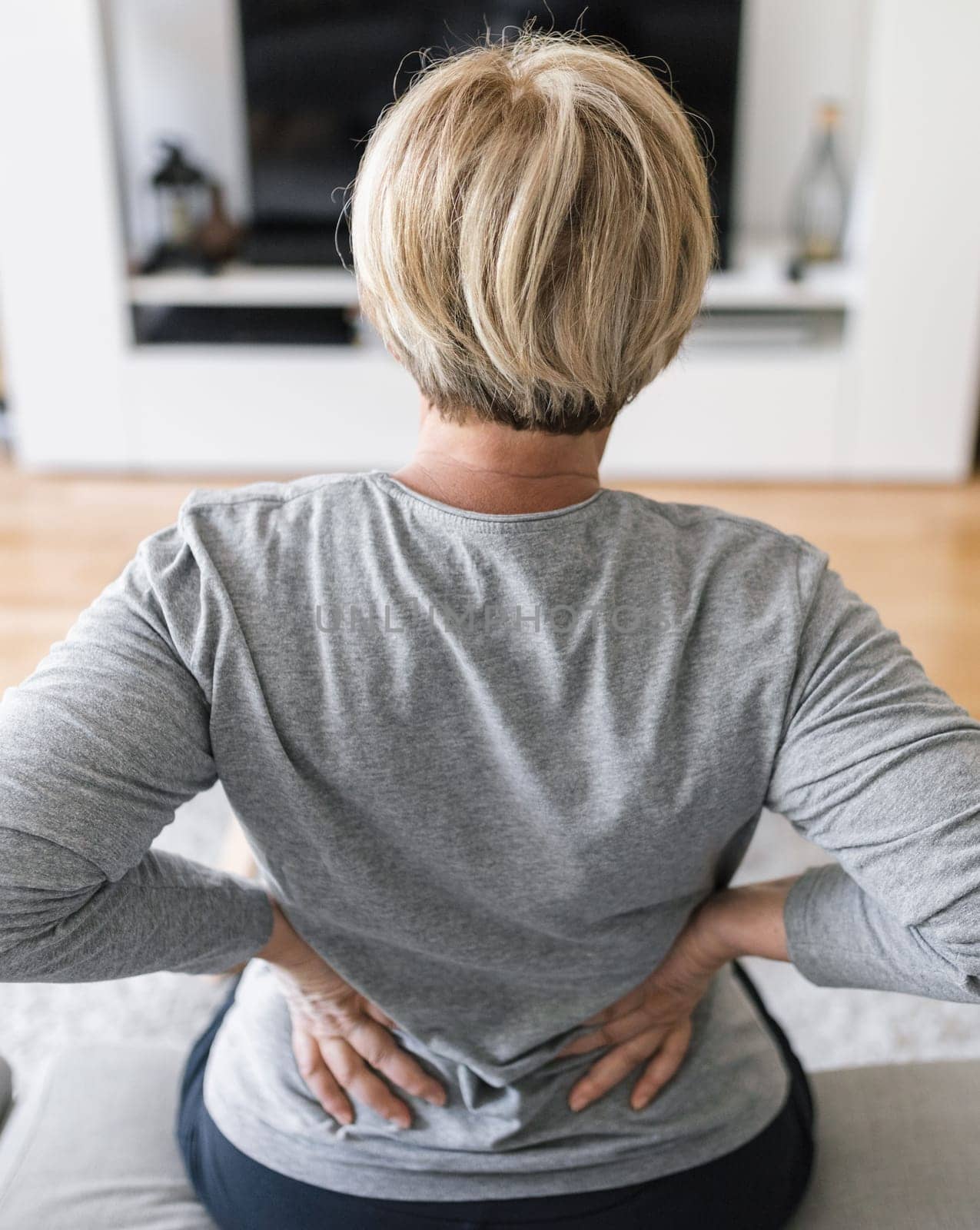 Elderly woman at home with lower back pain