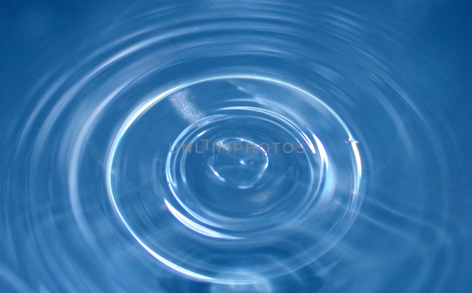 Water drop falling into water making a perfect droplet splash. ..