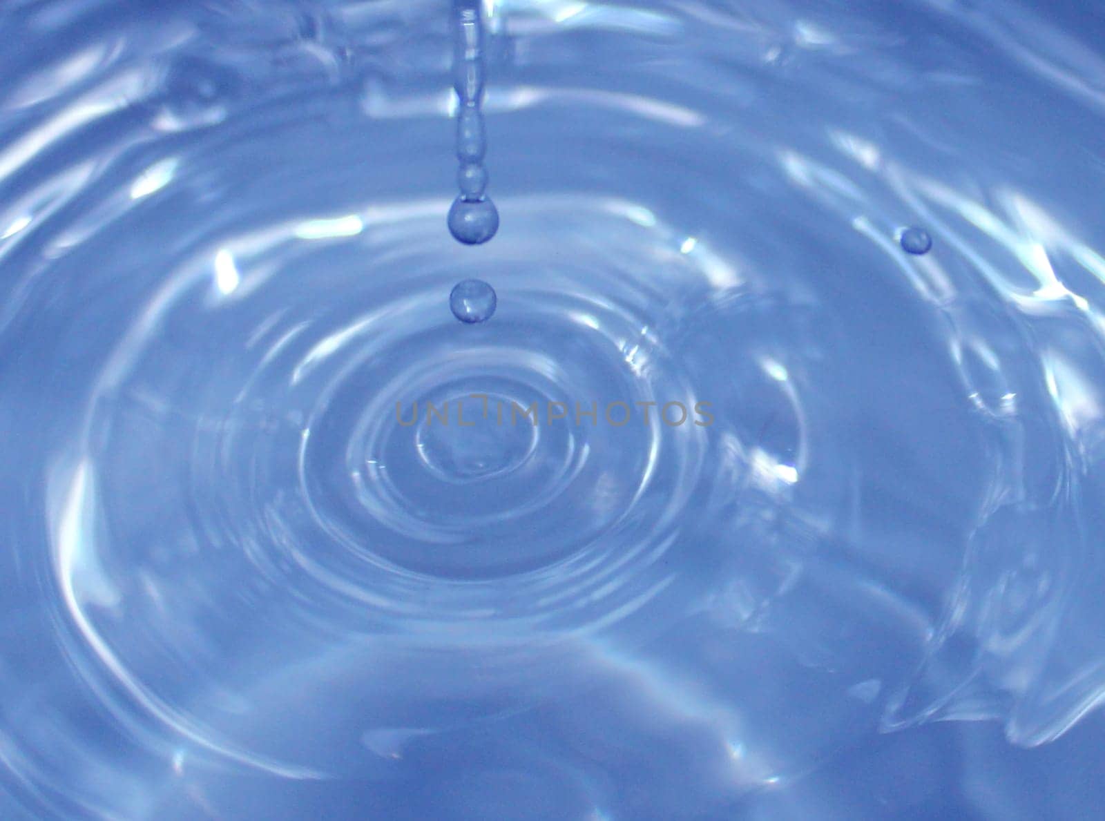 Water drop falling into water making a perfect droplet splash..