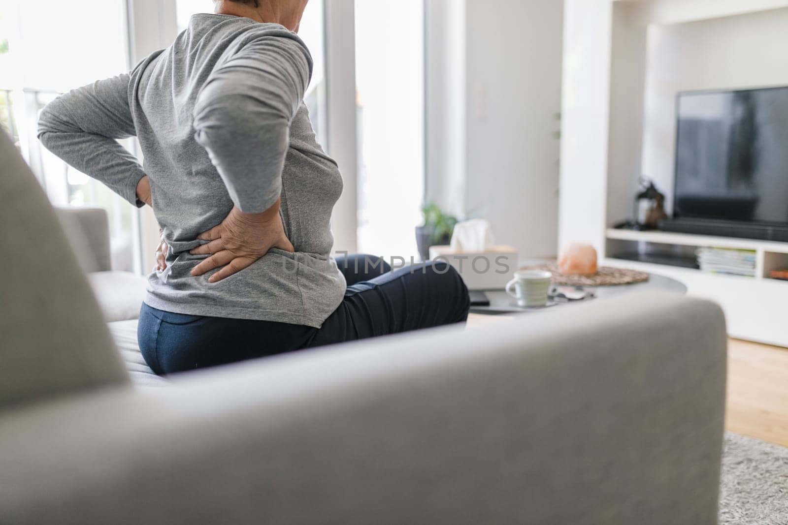 Elderly woman at home with lower back pain