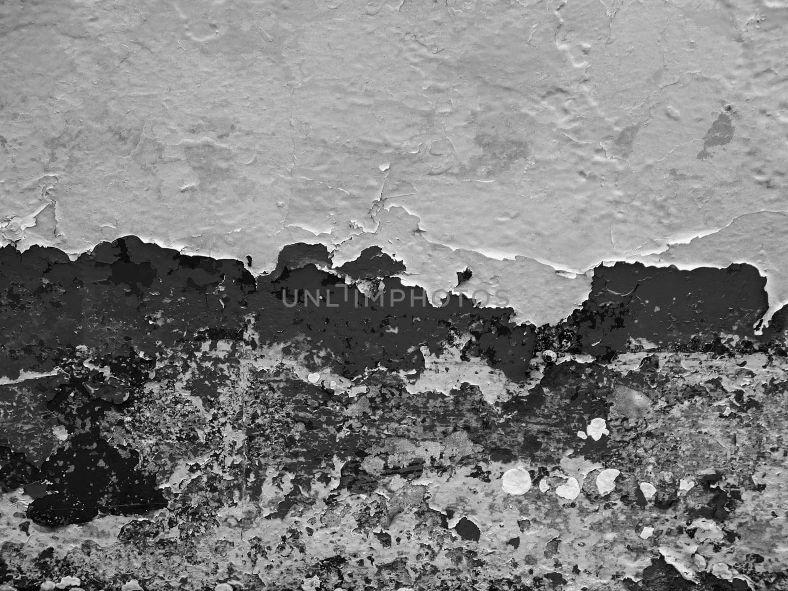 Format-filling view of a metal wall with chipped blue paint in various shades of blue in black and white.
