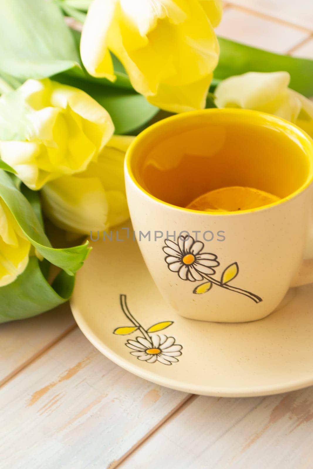 still life tea mug and bouquet of yellow tulips white fabric, vertical image