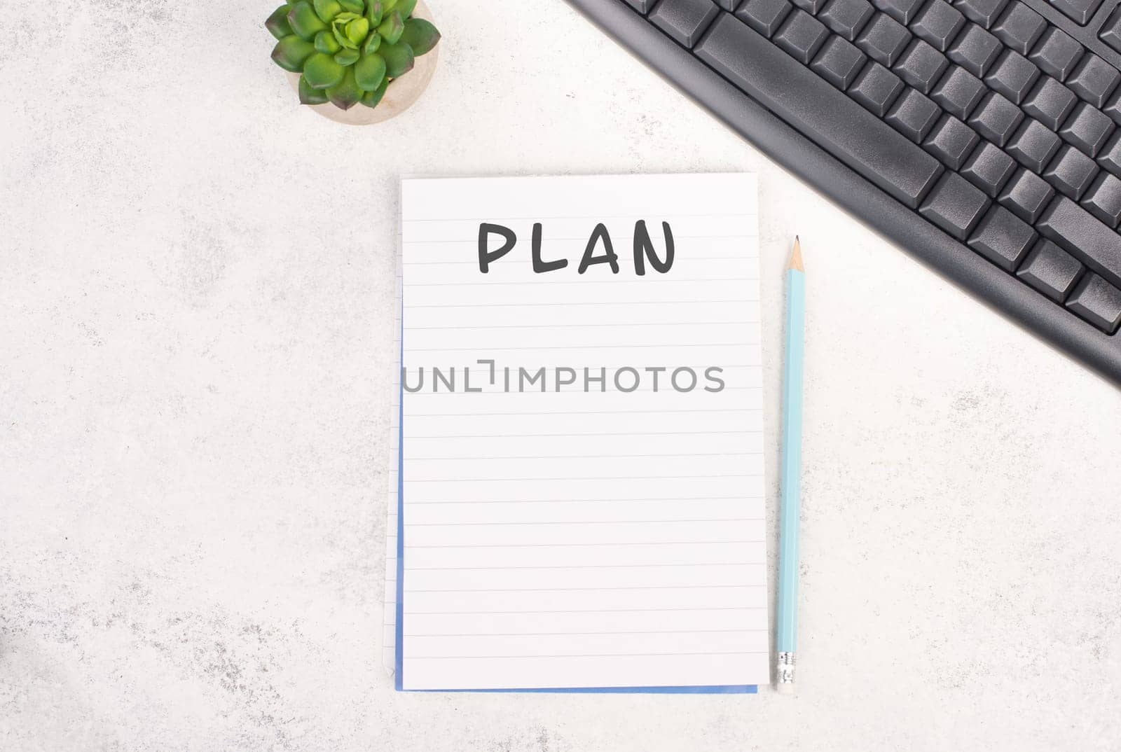 Paper with the word plan besides a pen, computer keyboard and a cactus, textured background, brainstorming for new ideas, writing a message, making a plan, home office desk