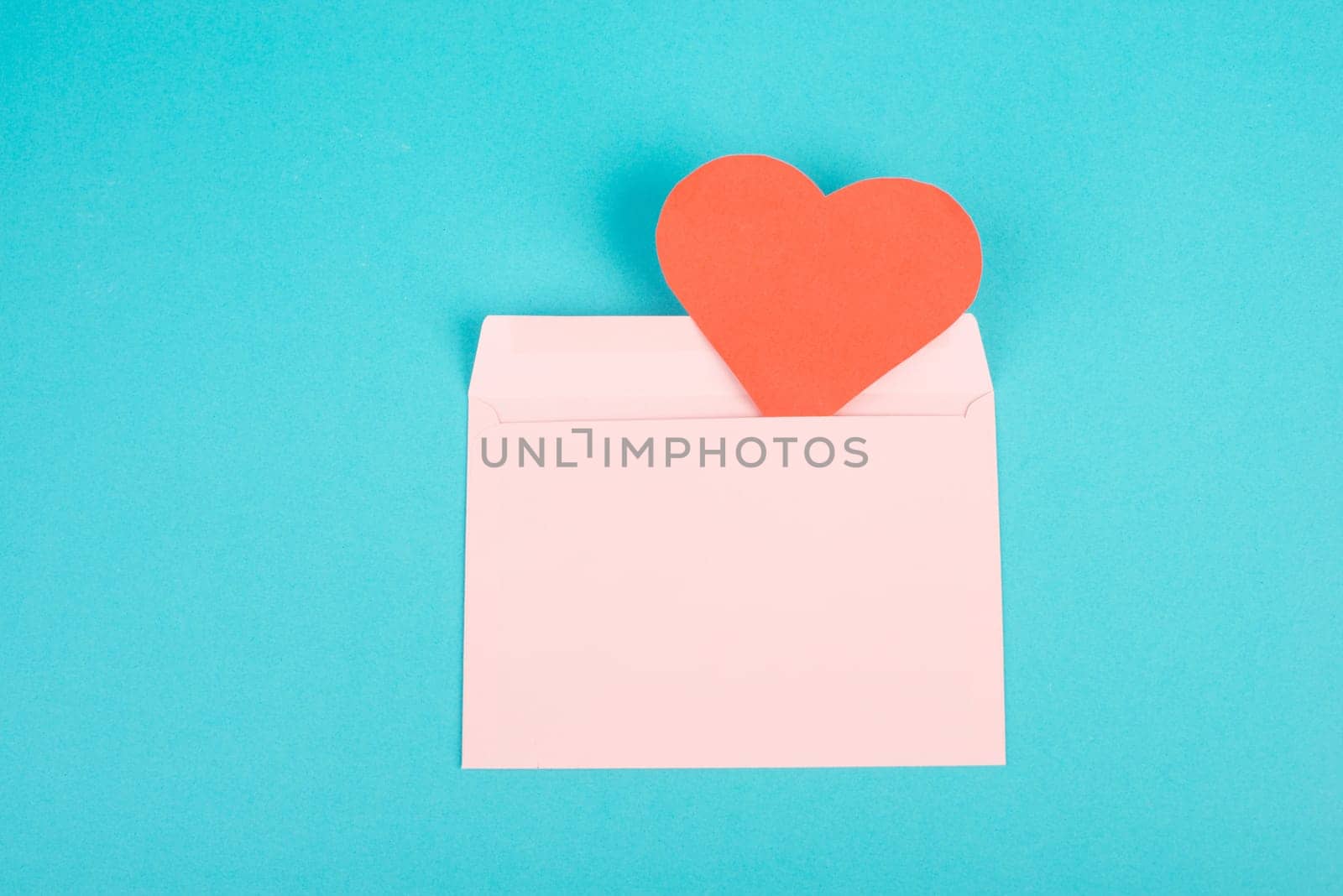 Pink envelope with a red heart, empty copy space, blue background, valintines day greeting card, romantic mail, love letter