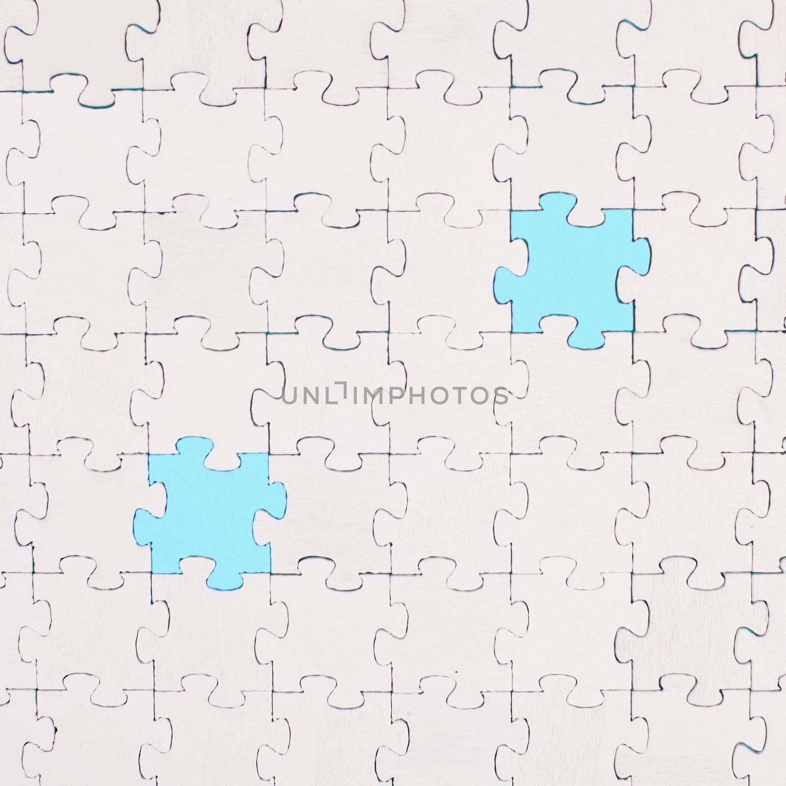 White jigsaw on a blue background, missing parts, working together as a team, searching for solutions, the last piece