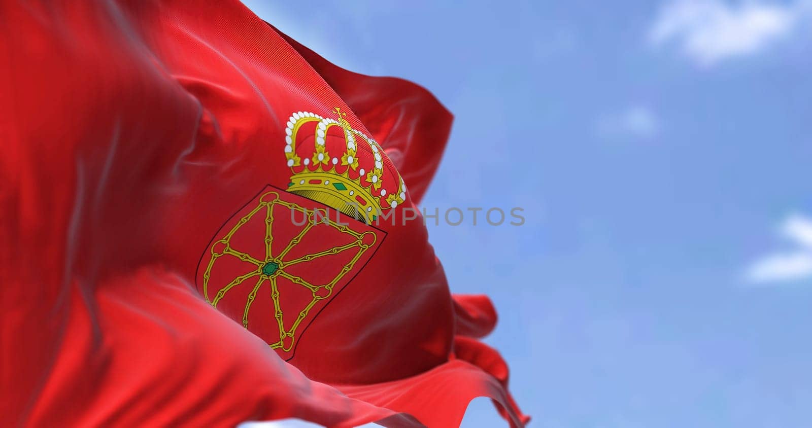 The Navarre flag waving in the wind on a clear day. Navarre is an autonomous community and province in northern Spain