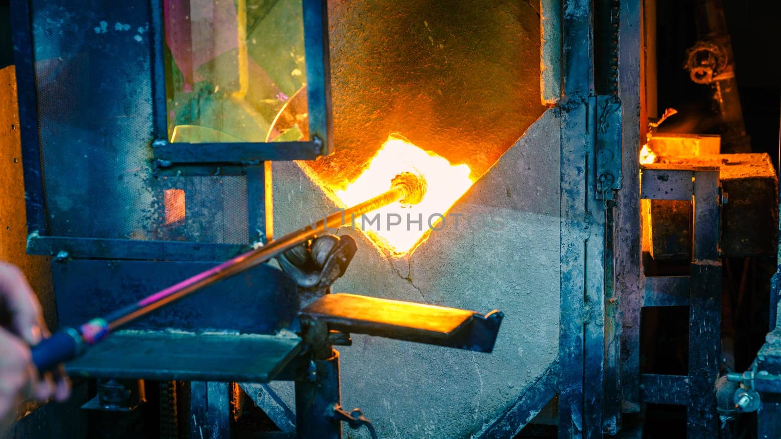 Softening glass in a kiln during glassblowing process