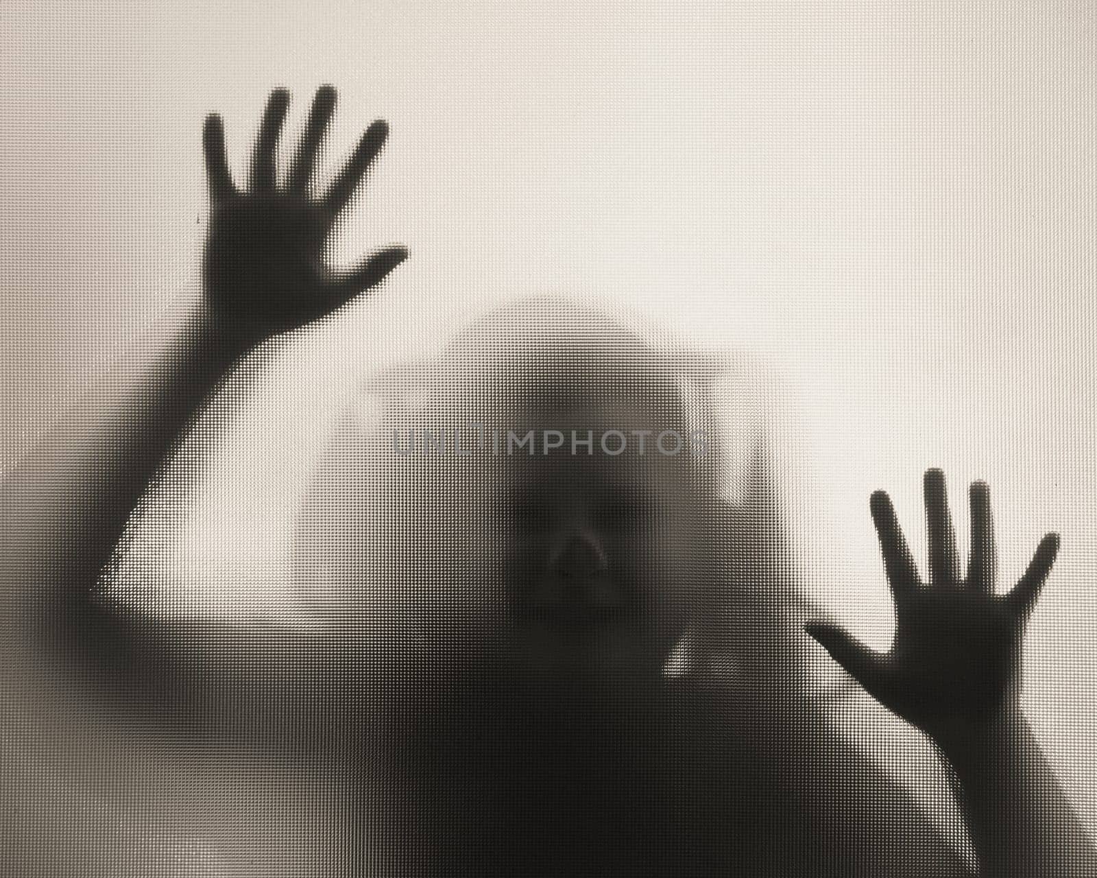 Horror ghost girl behind the matte glass in black and white. Halloween festival concept.