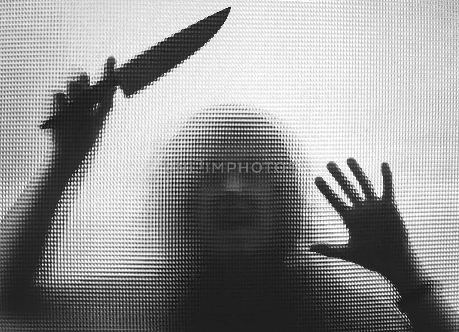 Horror, halloween background - Shadowy figure behind glass holding a knife