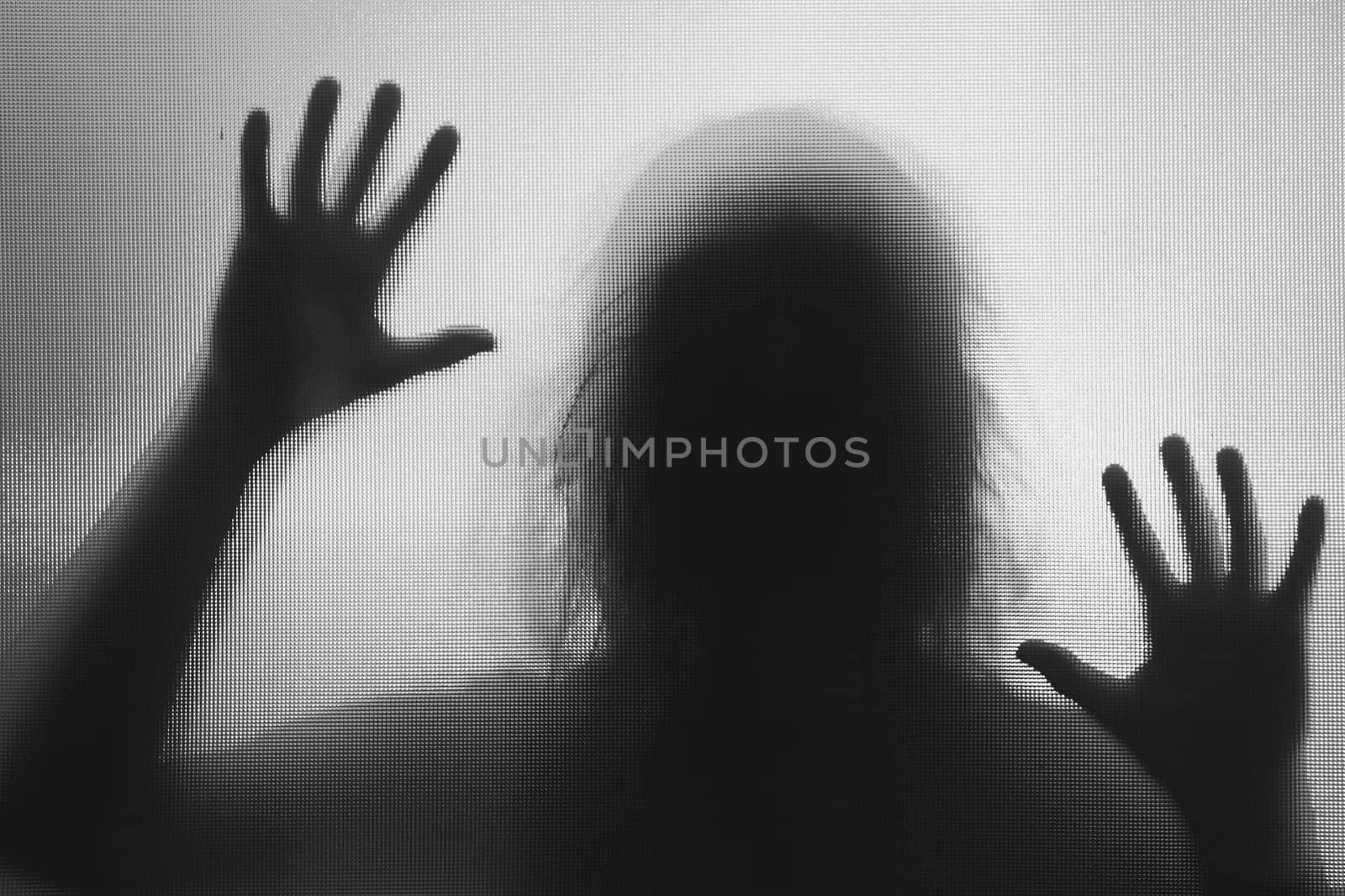 Horror ghost woman behind the matte glass in black and white. Halloween festival concept.