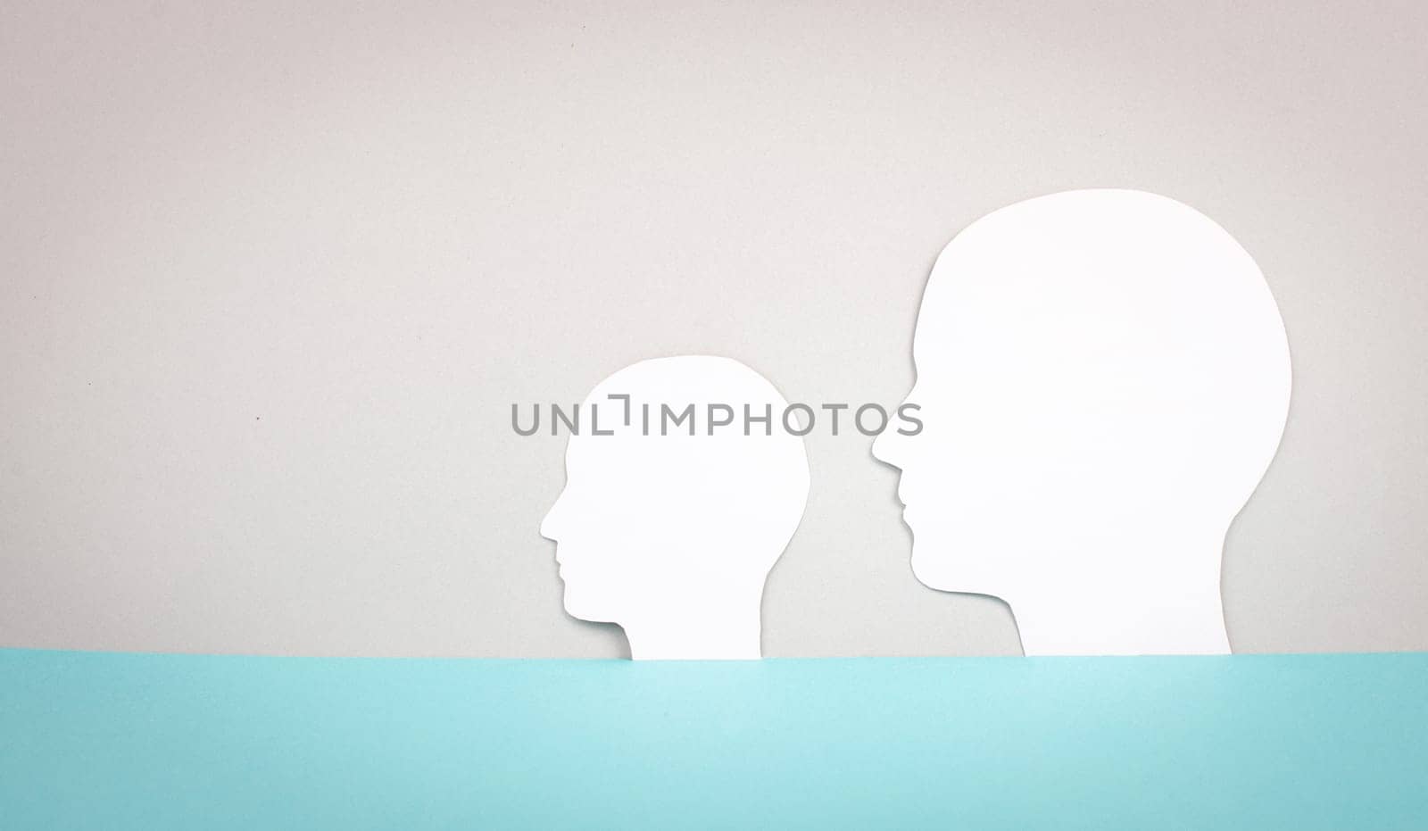 Two silhouette faces looking to the same direction, copy space for text, adult and child, anonymous profil of men, communication concept