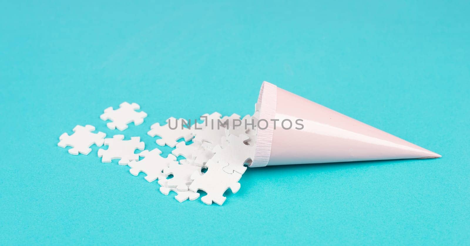Cone with white puzzle pieces, blue background, spreading the jigsaw parts, searching for ideas and solutions, brainstorming as a team, flat lay