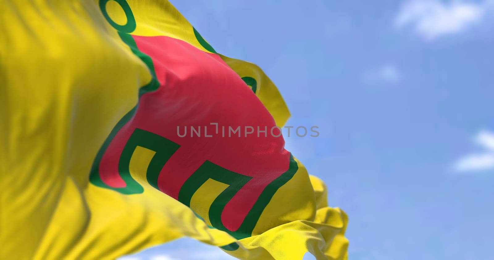 Rear view of the Auvergne flag waving in the wind on a clear day. Auvergne is a former administrative region in central France. Selective focus