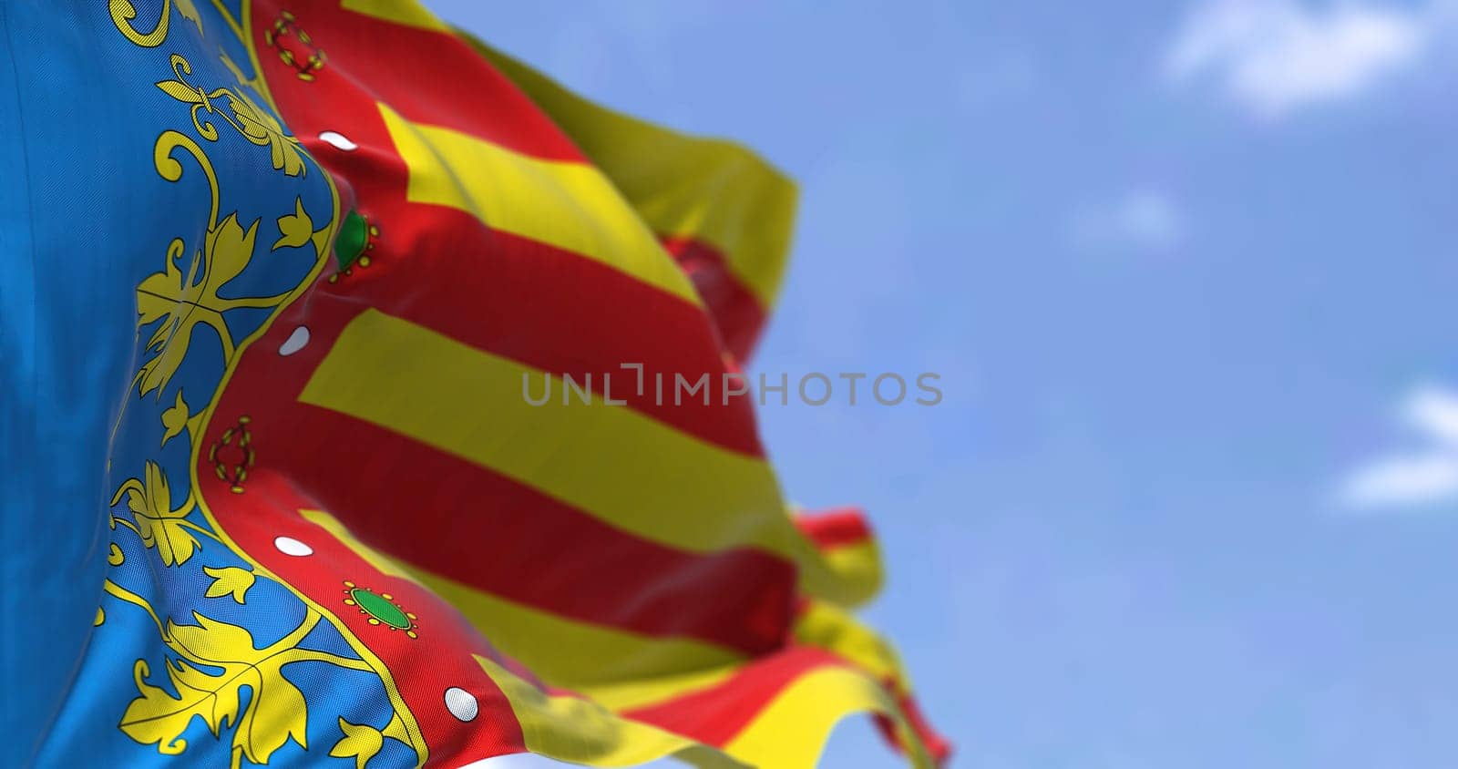 The Valencian Community flag waving in the wind on a clear day. The Valencian Community is an autonomous community of Spain. Seamless loop in slow motion
