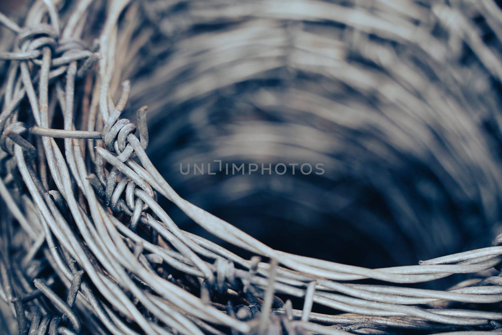 macro closeup of large roll of steel barbed wire used for fence construction