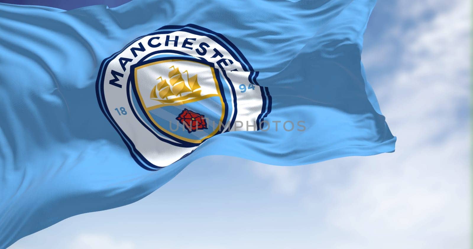 Manchester, UK, May 2022: The flag of Manchester City Football Club waving in the wind on a clear day. Manchester F.C. is a professional football club based in Bradford, Manchester