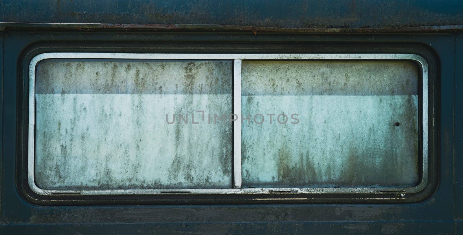 front view closeup of old rusted car window with metallic chrome frame and dirty opaque glass rectangular shape