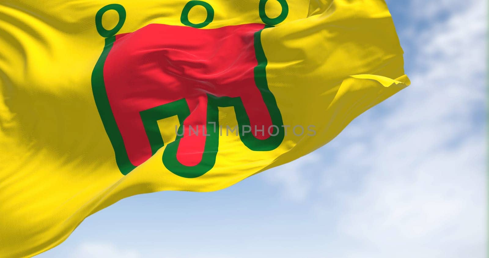 View of the Auvergne flag waving in the wind on a clear day. Auvergne is a former administrative region in central France. Selective focus