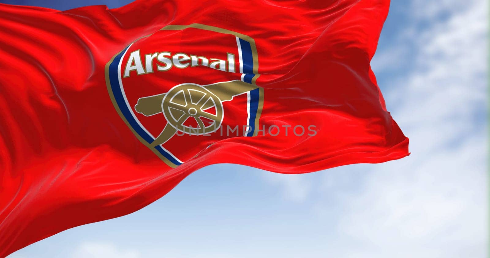 London, UK, May 2022: The flag of Arsenal Football Club waving in the wind on a clear day. Arsenal is a professional football club based in Islington, London, England