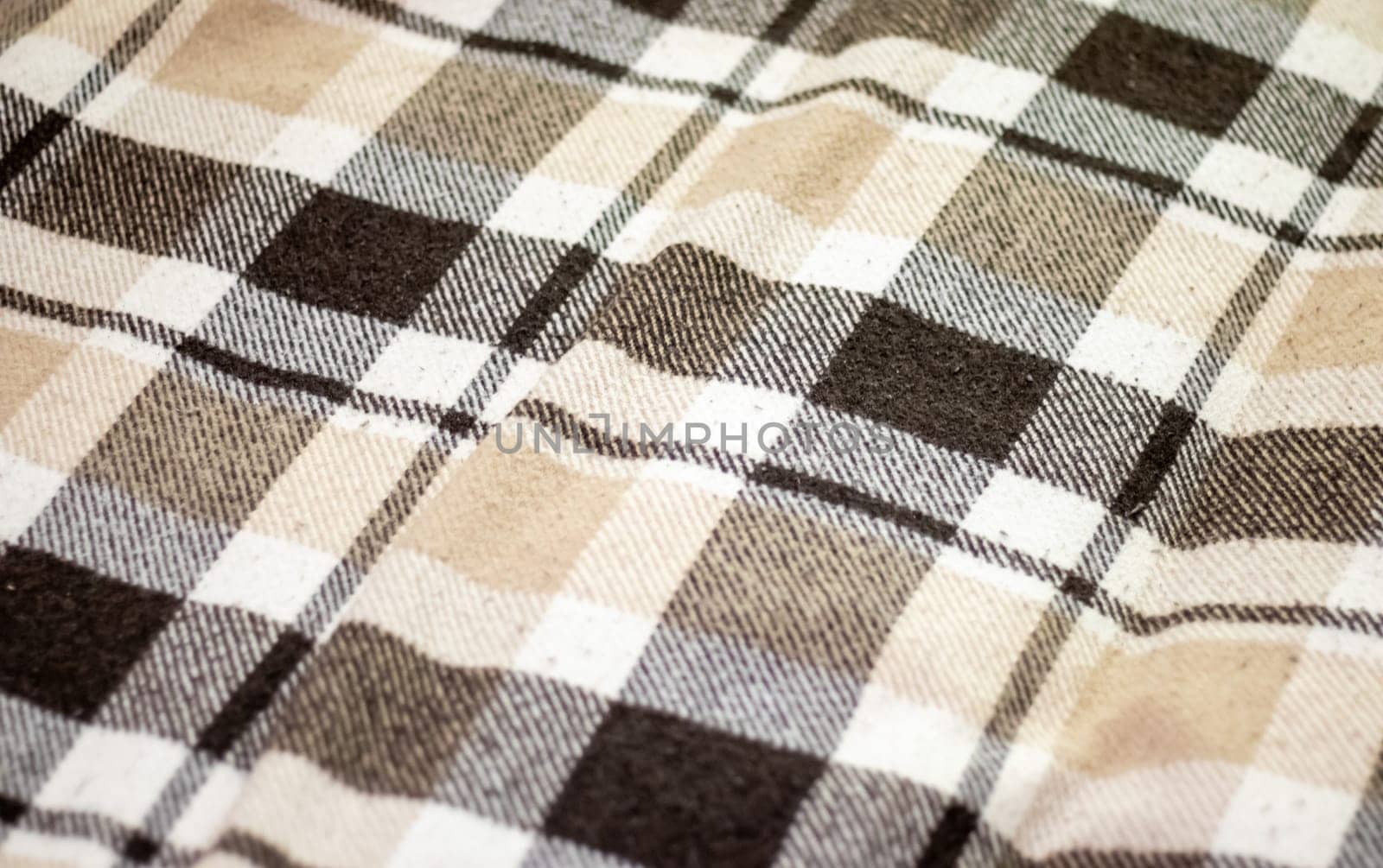 Blanket. Texture of checkered wool fabric in brown color. Checkered texture. Warm brown alpaca wool or cashmere blanket. Beige, brown square shaped wool fabric for home design
