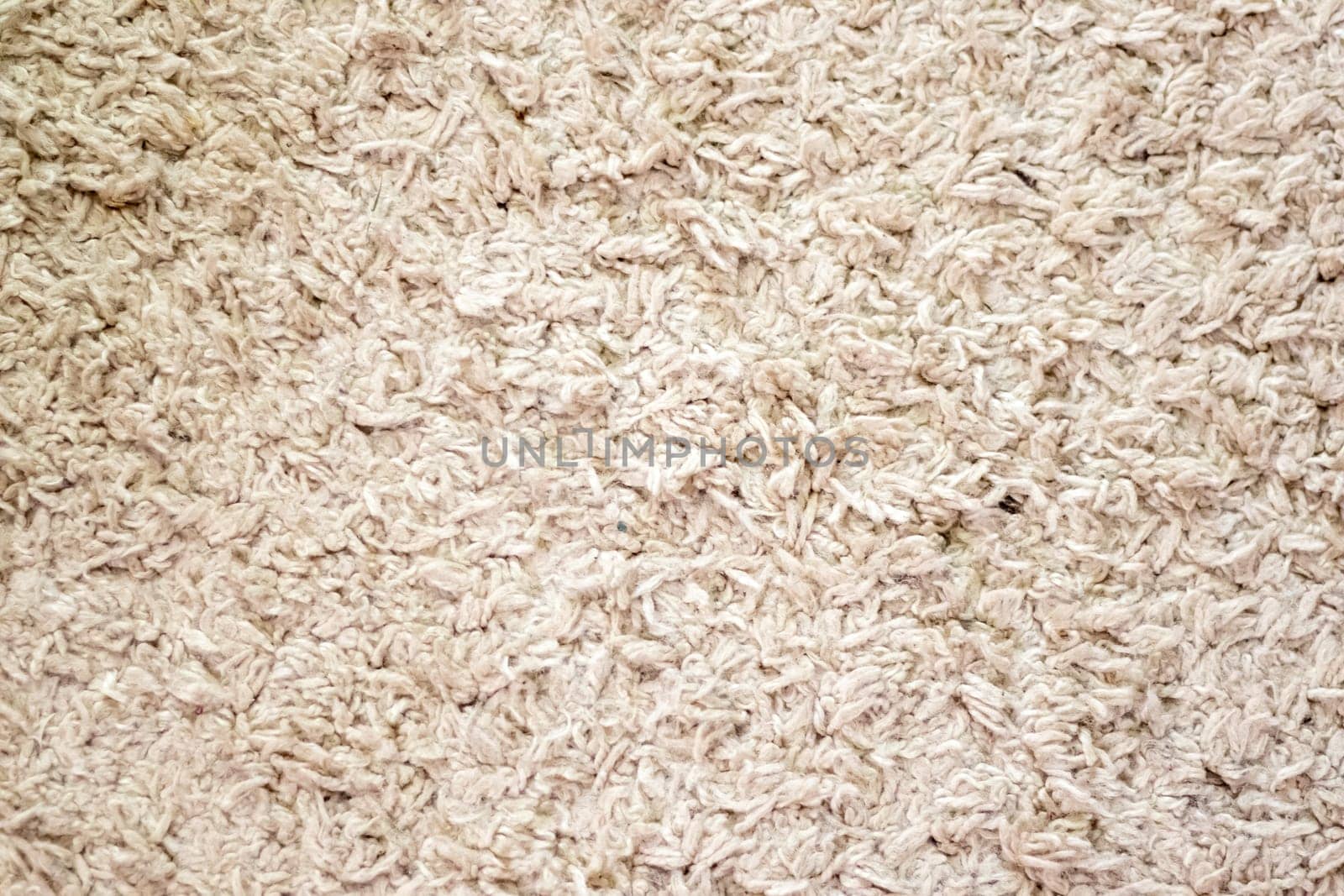 Beige background texture of towel or home carpet. Top view, flat lay. Textile texture of carpet. White or cream pile carpet. Stylish carpet on the floor in the room. Interior Design