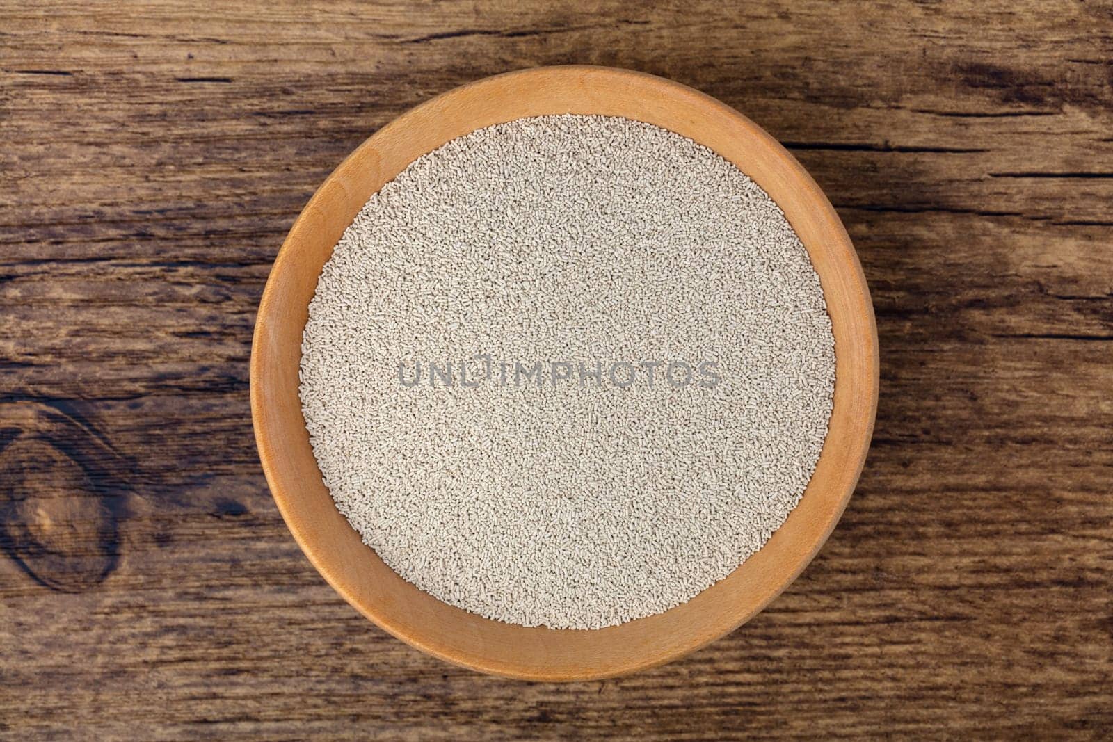 Dry Yeast in a bowl over wooden background