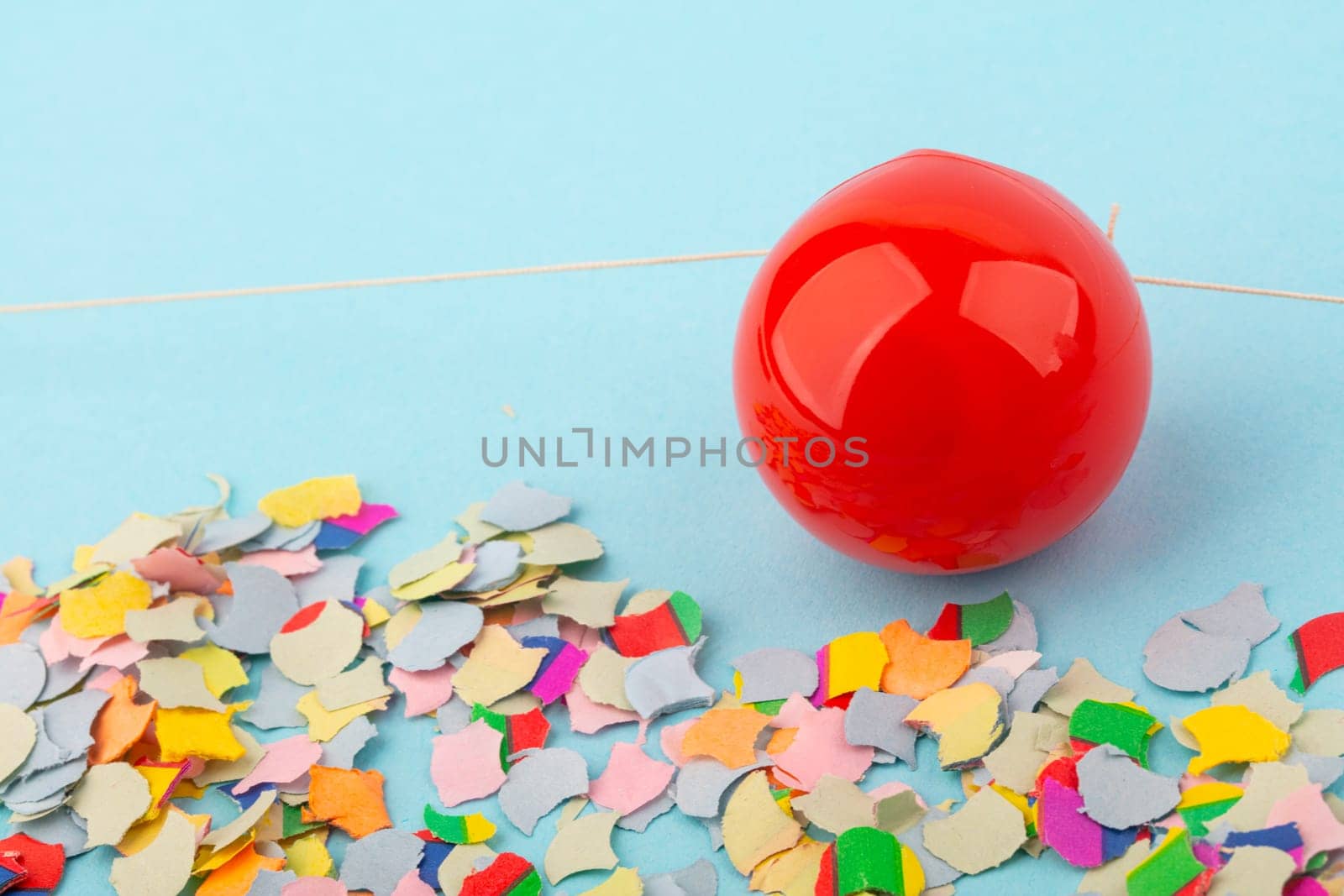 Red Nose with confetti over light blue background.