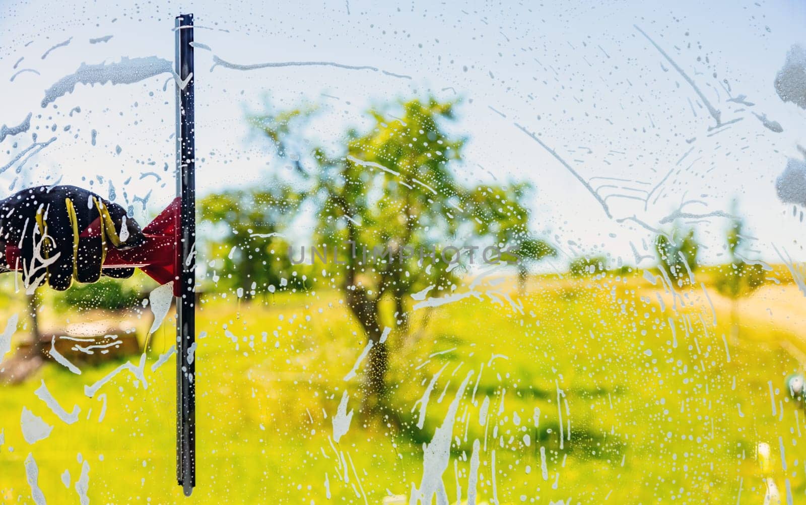 Professionell window cleaning Service with squeegee on a sunny Day
