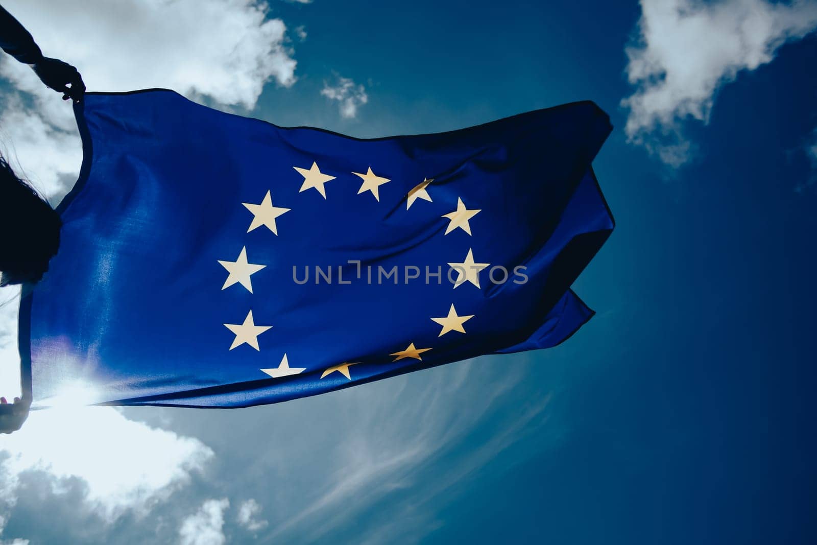 Waving European Union flag on blue sky.
