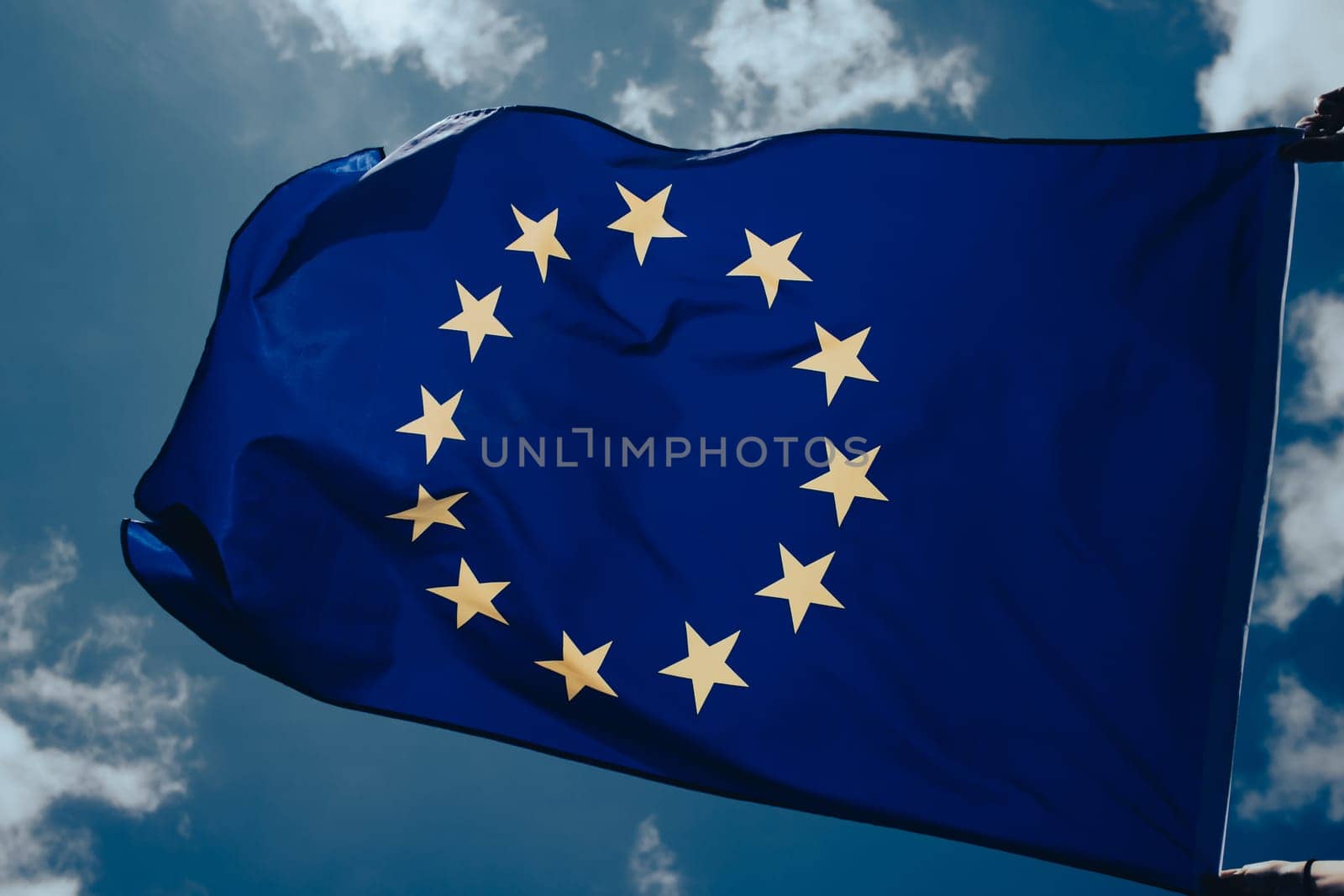 Waving European Union flag on blue sky.