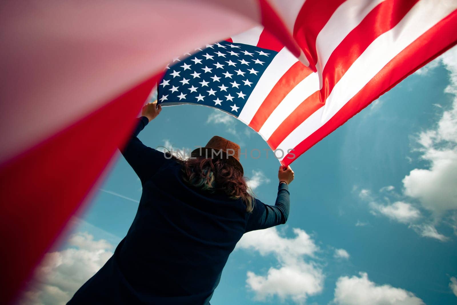 Young woman holding american USA flag. Independence Day or traveling in America concept.