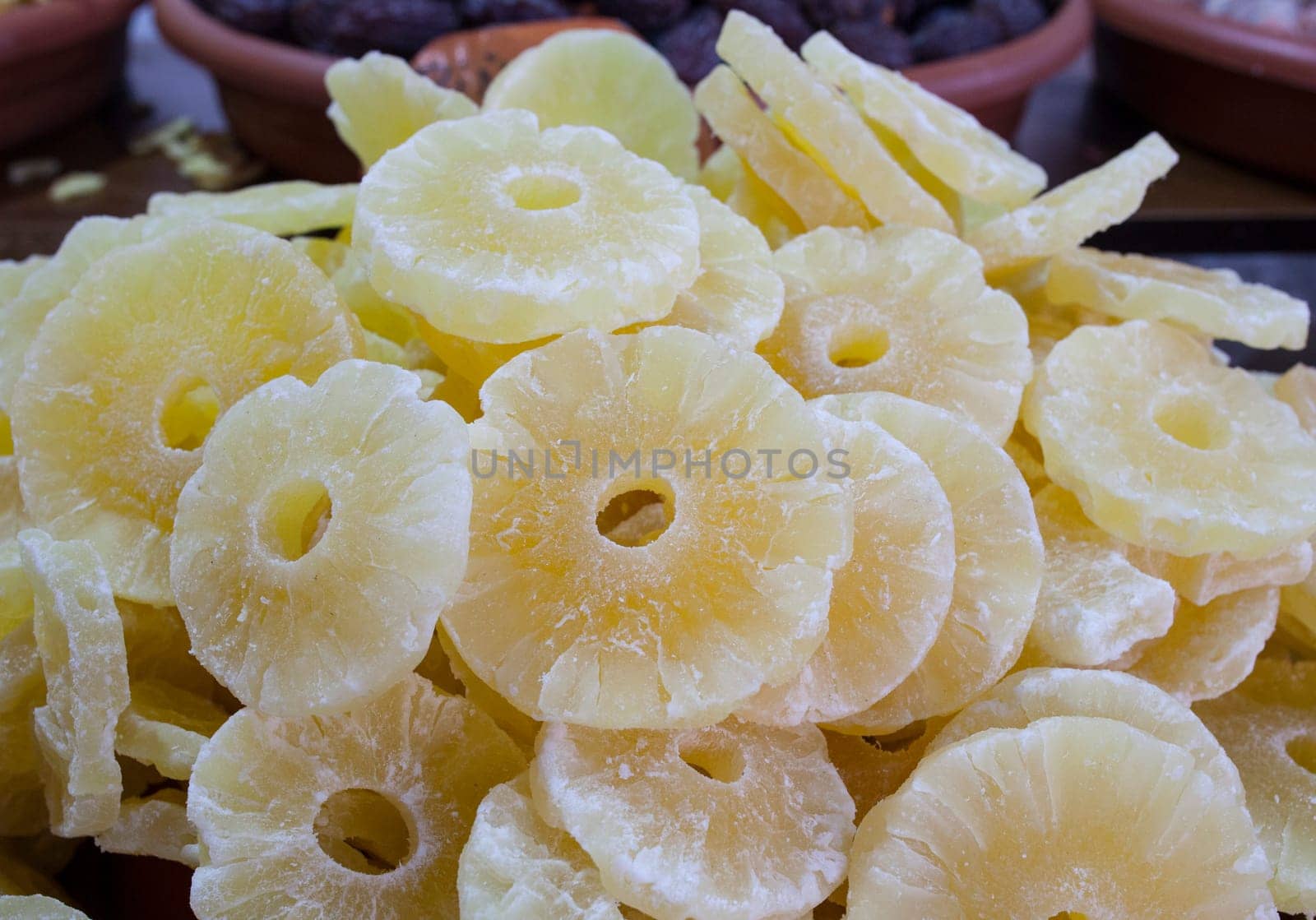 Bowl with pineapple dried fruit. Slices displayed at street market stall