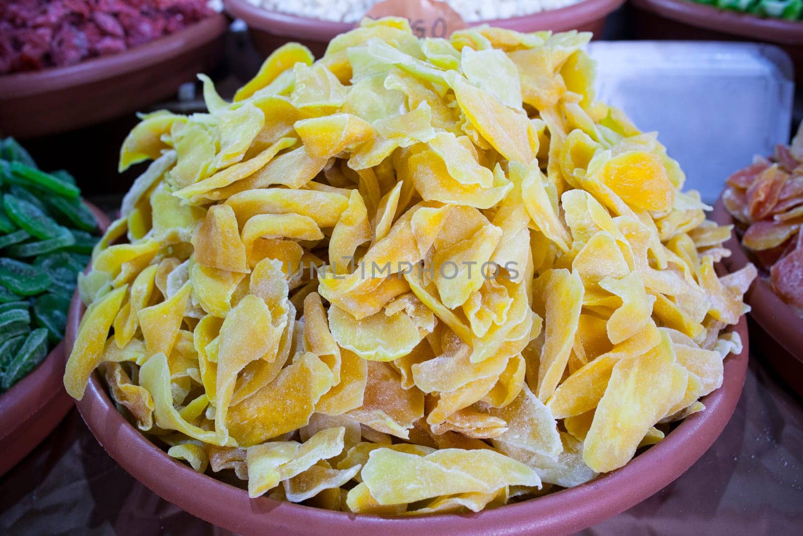 Bowl with dried mango fruit. Slices displayed at street market stall
