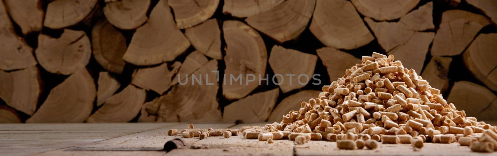 Ground level of chopped woodpile stacked in rural house with heap of compressed fuel pellets in daylight