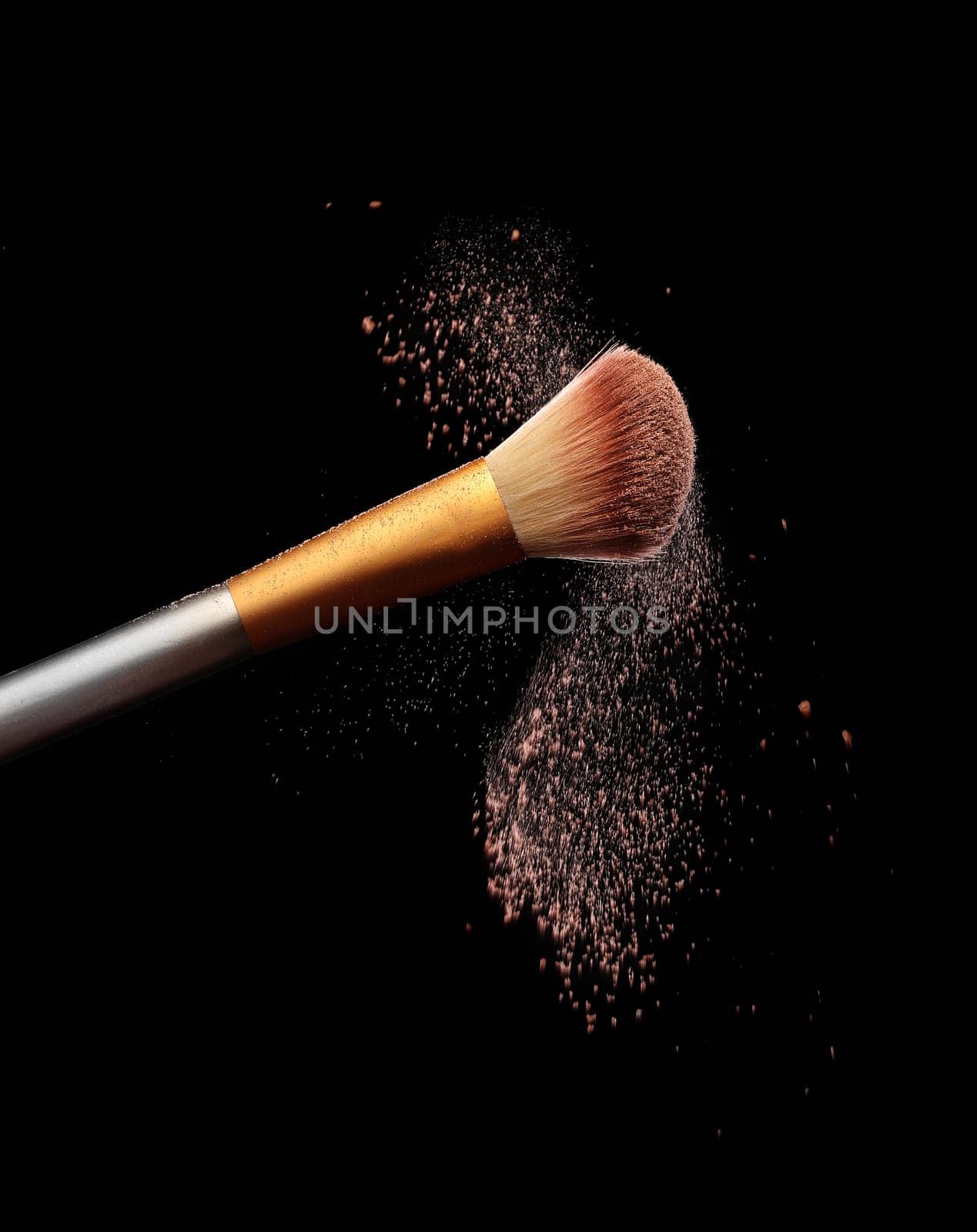 Make up brush with cosmetic powder splash, over black background. Splash image