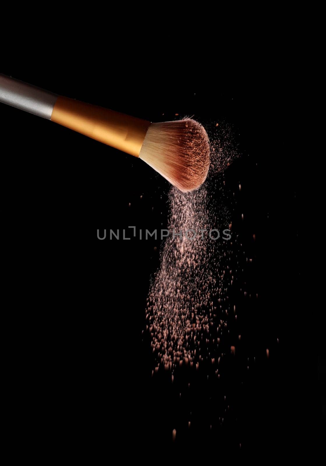 Make up brush with cosmetic powder splash, over black background. Splash image
