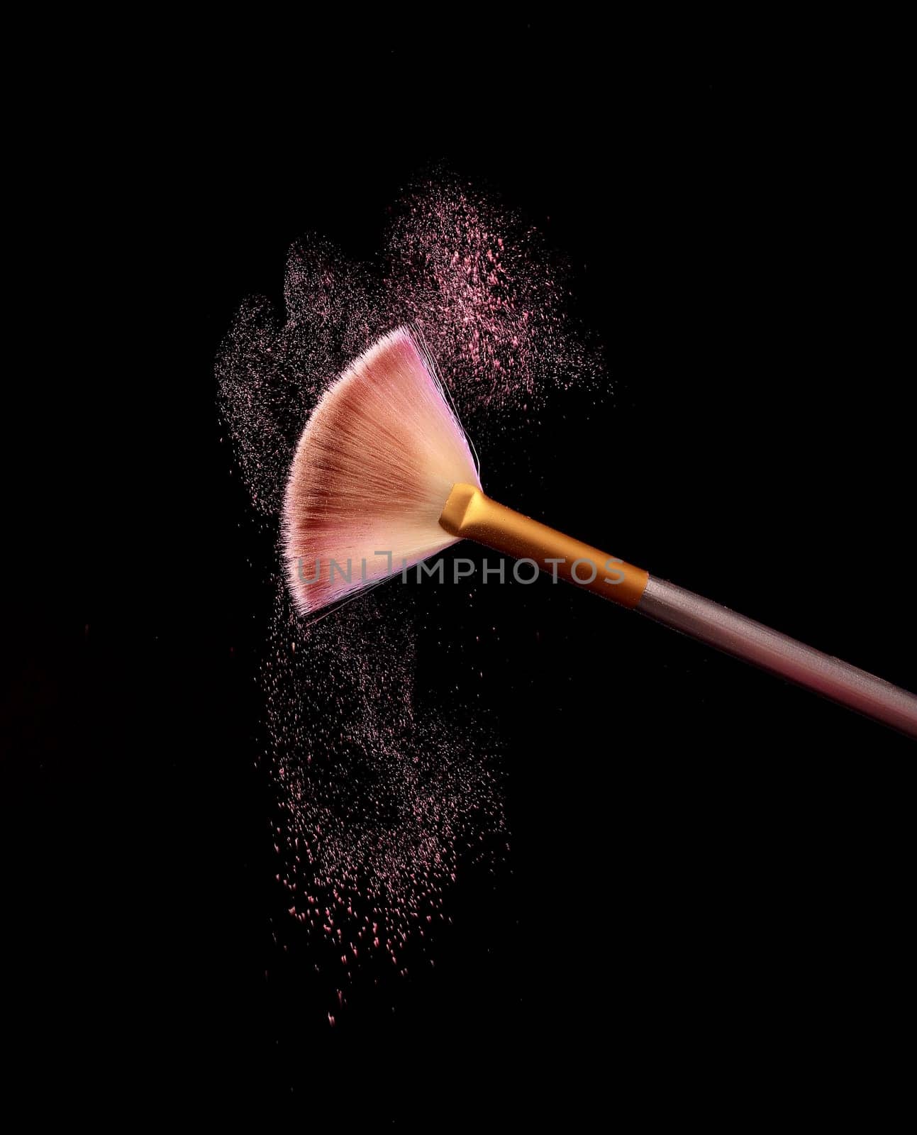 Make up brush with cosmetic powder splash, over black background. Splash image
