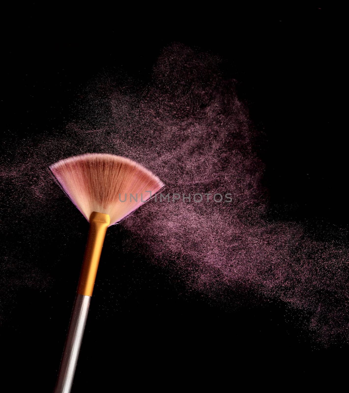 Make up brush with cosmetic powder splash, over black background. Splash image