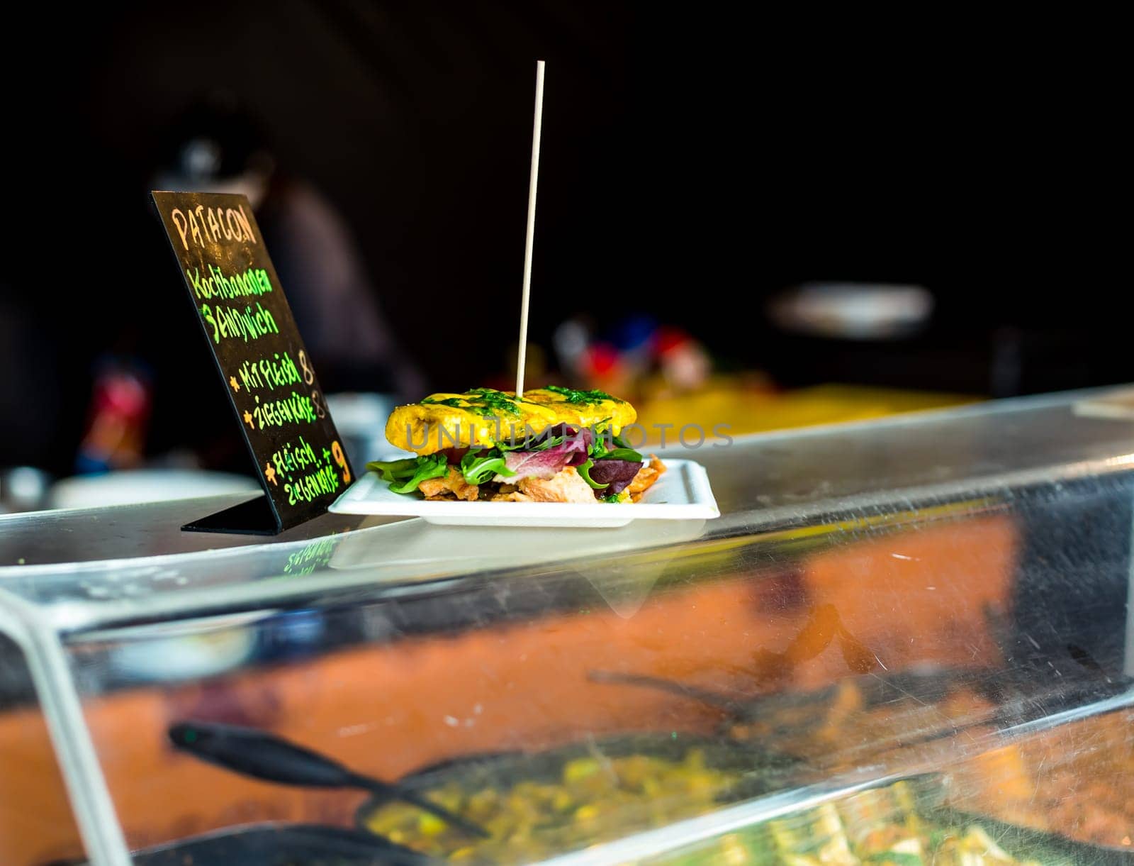 Patacon sandwich - traditional sandwich made from cooking bananas (plantains) with chicken meat and lettuce. Freshly prepared at food truck. African food.