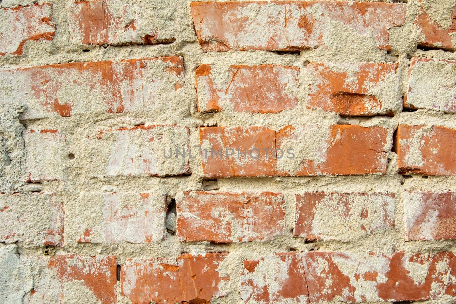 Wall of old red bricks and cement plaster, background
