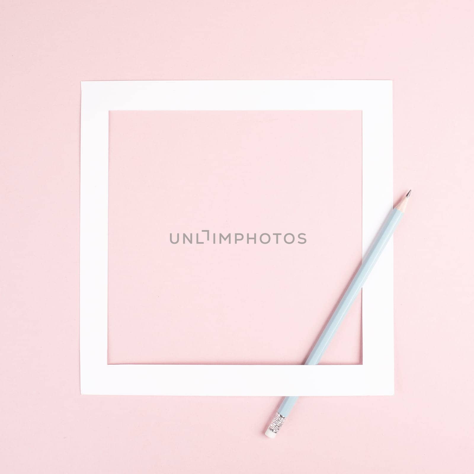 Pencil on a pink paper background, white frame with copy space for text, minimalism, creative and business concept, pastel colored