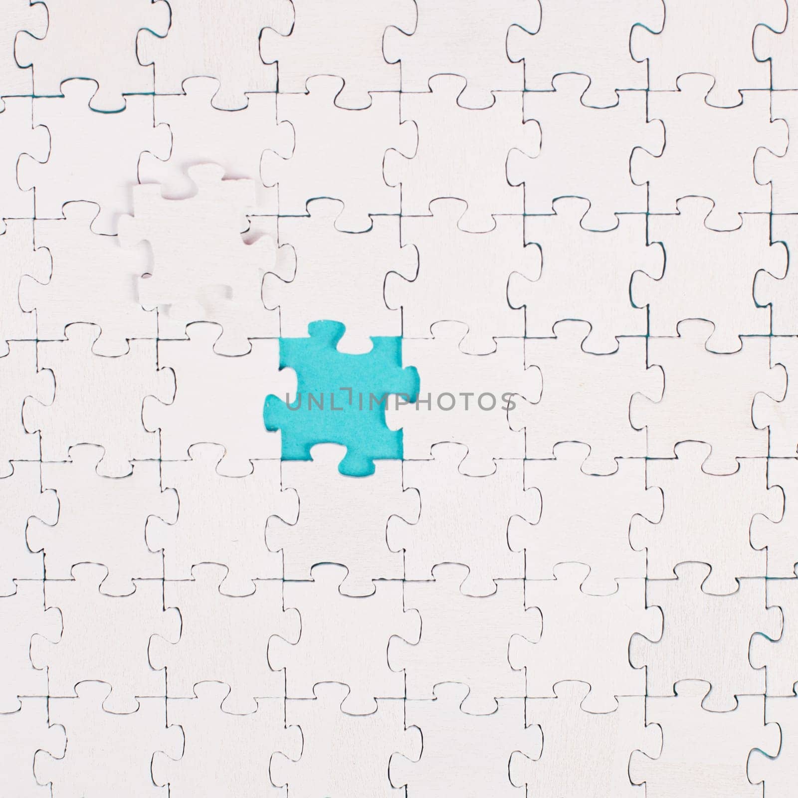 White jigsaw on a blue background, missing parts, working together as a team, searching for solutions, the last piece